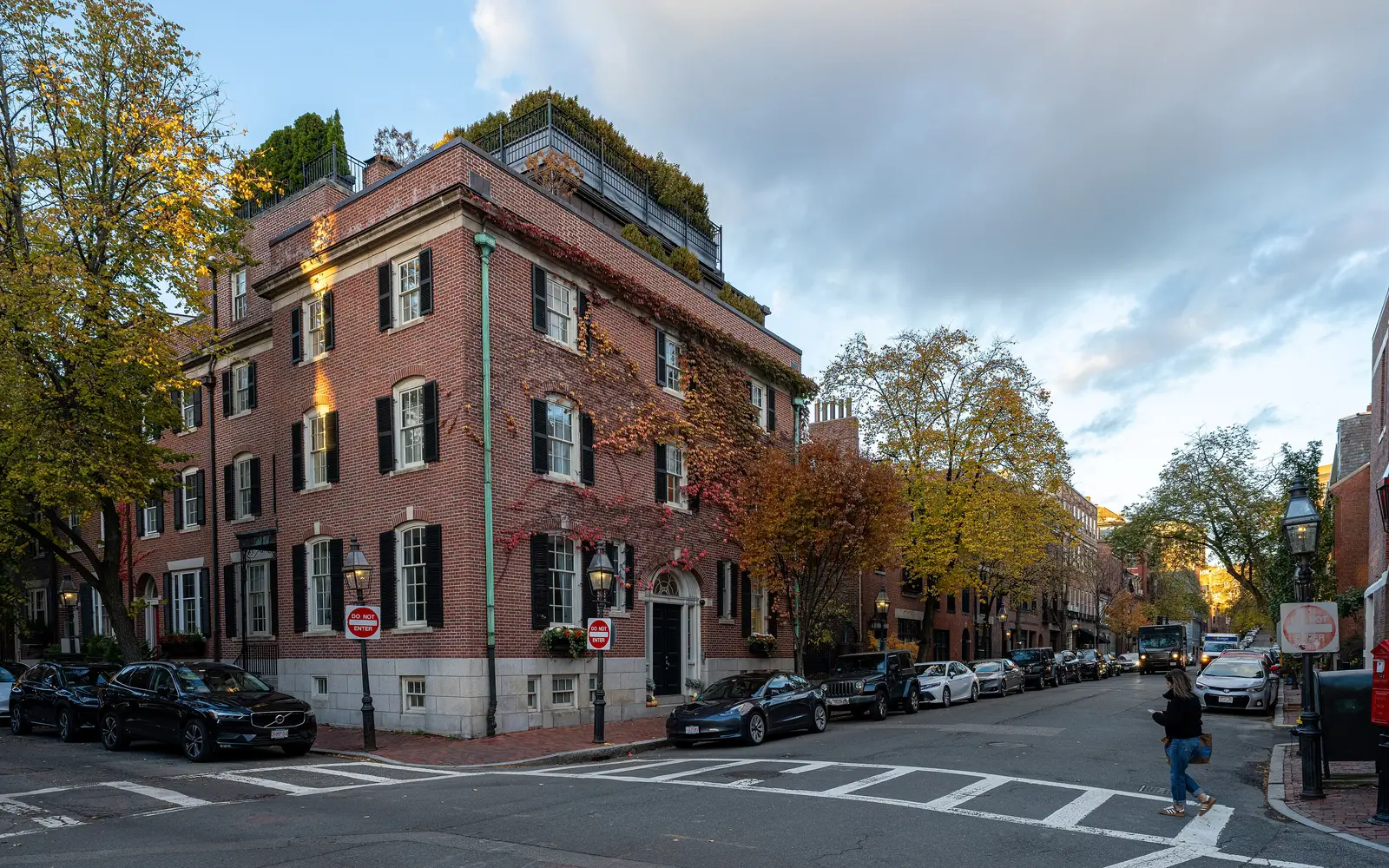 Brick rowhouses on a Beacon Hill street corner in Boston, in autumn
